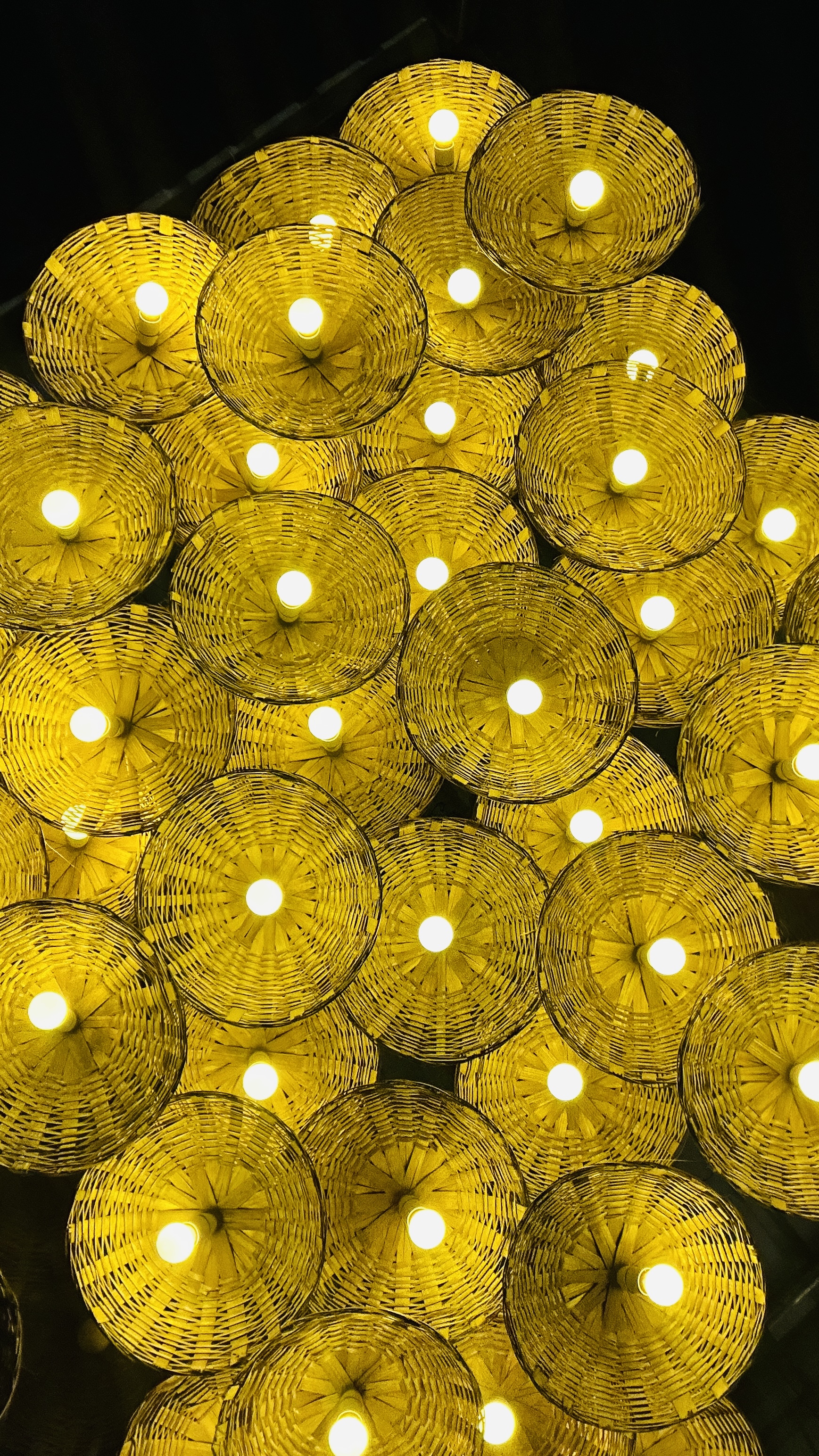 Woven pendant lights glowing warmly above a common seating area